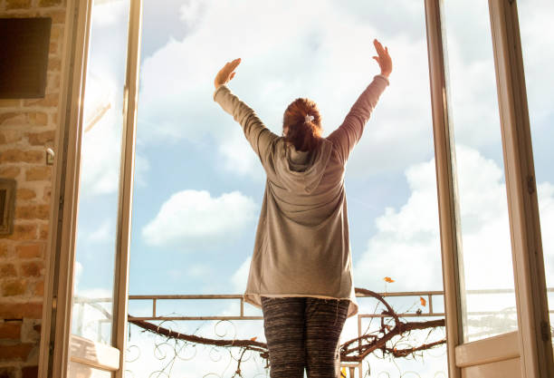 Person stretching on a balcony at sunrise